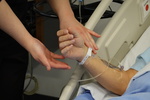 Nurse assessing IV site